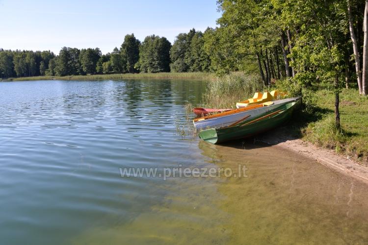 Ežero pakrantė, valtys, vandens dviratis